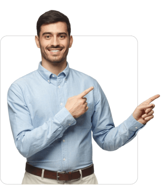 A smiling man with dark hair wearing a light blue shirt and beige trousers, pointing with both hands to the right.
